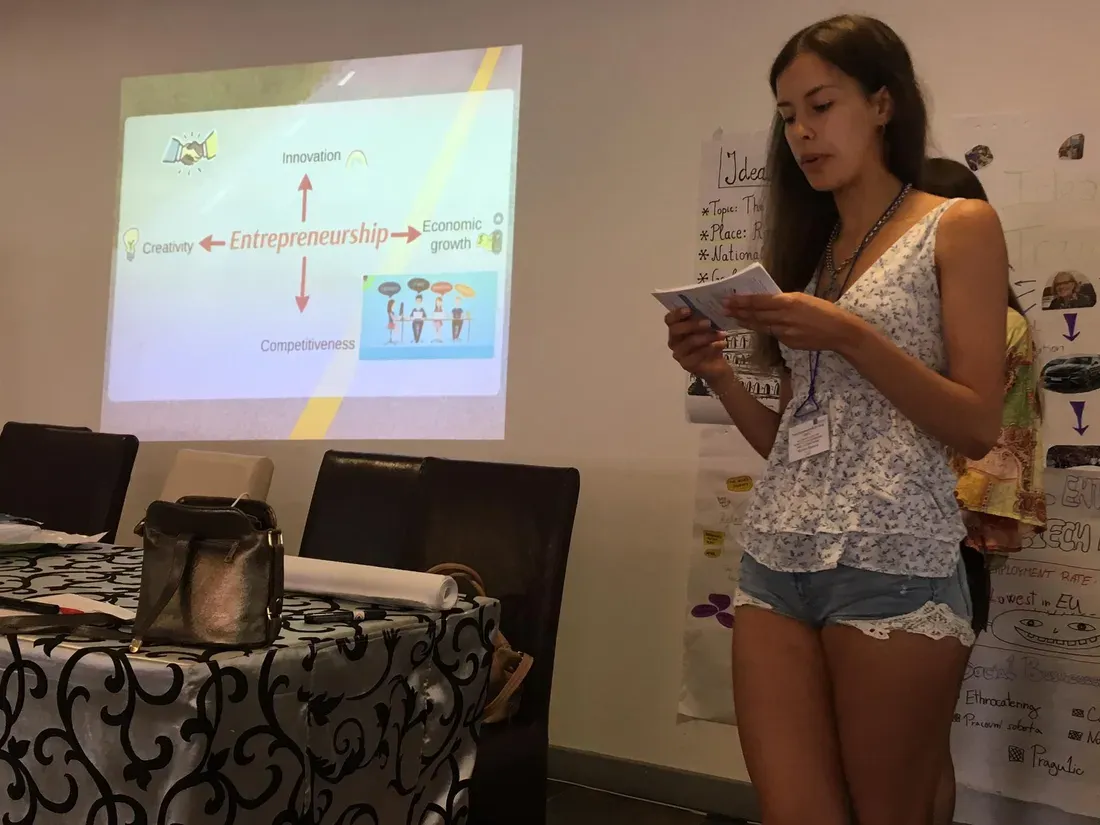 A participant presents next to a slide on entrepreneurship, innovation and economic growth